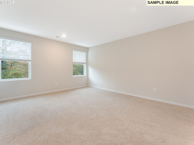 unfurnished room with light colored carpet