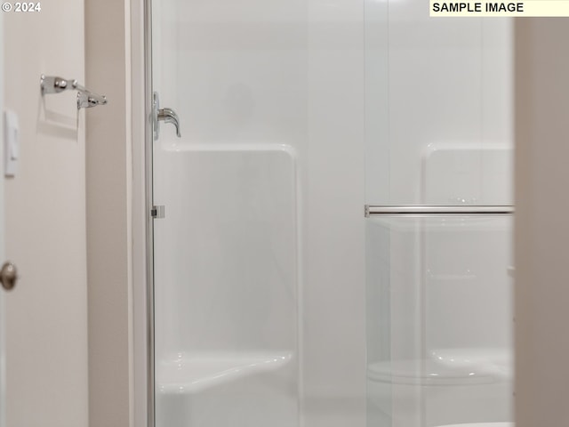 bathroom featuring a shower with shower door