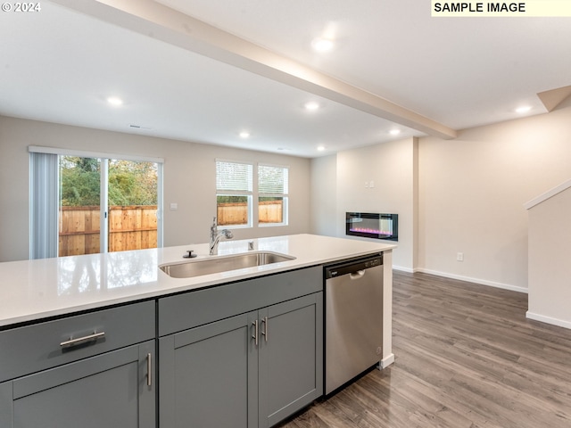 kitchen featuring gray cabinets, stainless steel dishwasher, dark wood-type flooring, and sink