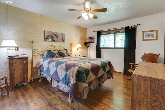 bedroom featuring a textured ceiling, dark hardwood / wood-style floors, and ceiling fan