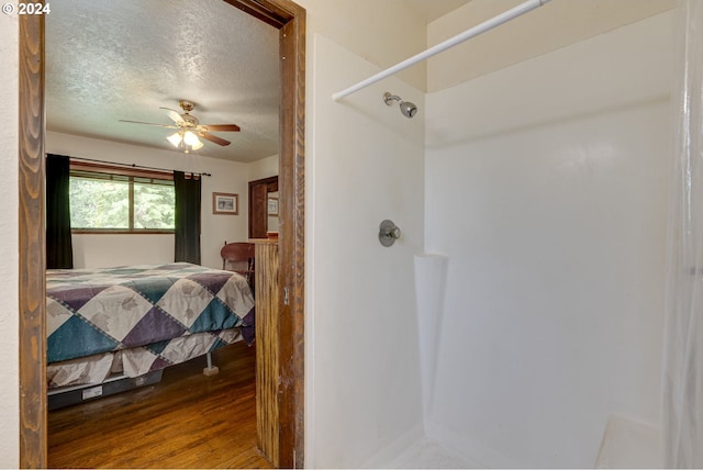 bedroom featuring ceiling fan, wood-type flooring, and a textured ceiling