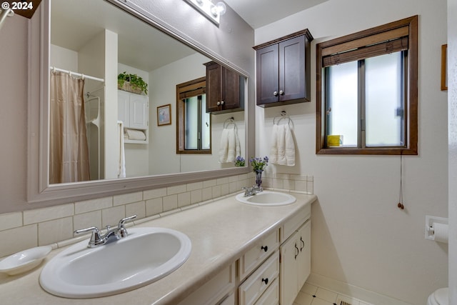 bathroom with vanity, toilet, tile patterned floors, and tasteful backsplash