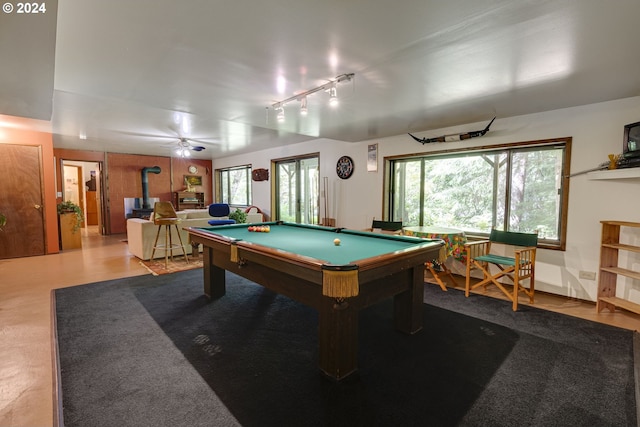 rec room with a wood stove, billiards, and track lighting