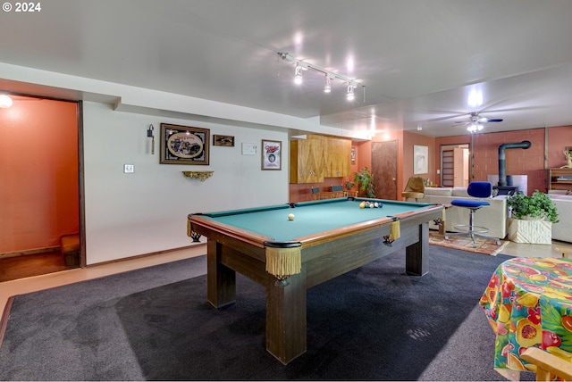 playroom featuring a wood stove, dark carpet, billiards, and rail lighting