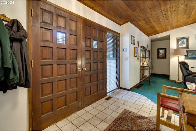 entryway with wooden ceiling, a healthy amount of sunlight, vaulted ceiling, and light tile patterned floors