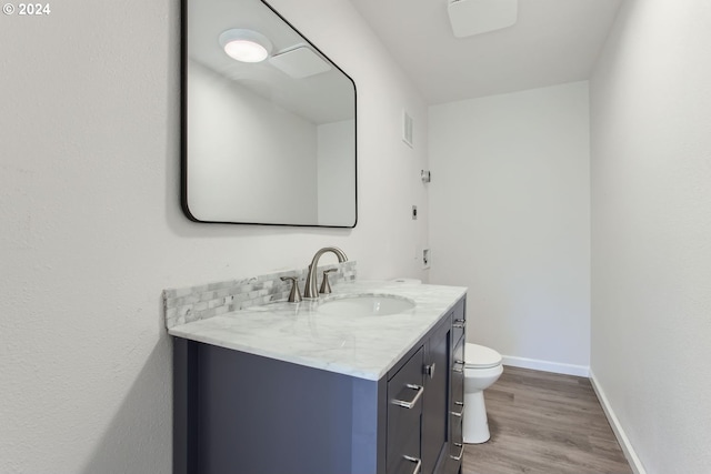 bathroom featuring vanity, toilet, and hardwood / wood-style floors