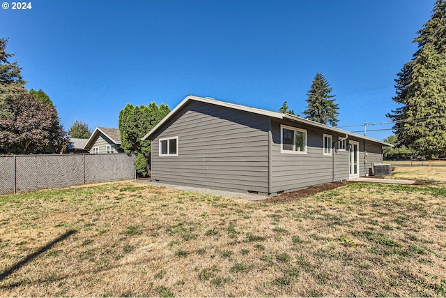 view of property exterior with central air condition unit and a lawn