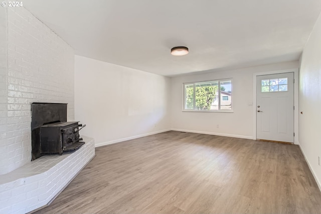 unfurnished living room with a wood stove and hardwood / wood-style flooring