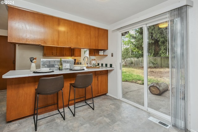 kitchen featuring kitchen peninsula, sink, and a kitchen bar