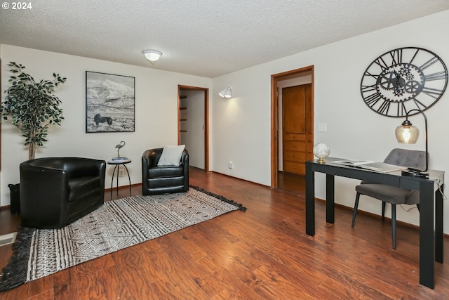 sitting room with a textured ceiling and dark hardwood / wood-style floors