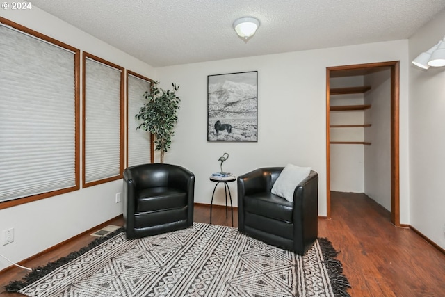 living area featuring a textured ceiling and hardwood / wood-style flooring