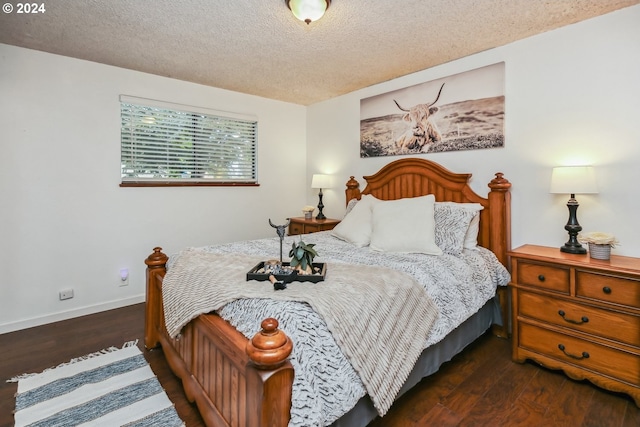 bedroom with a textured ceiling and dark hardwood / wood-style floors