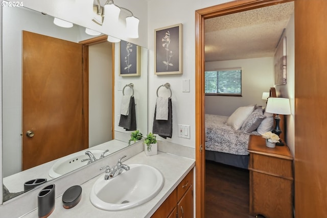 bathroom with a textured ceiling, vanity, and hardwood / wood-style floors