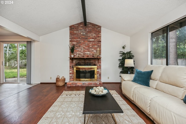 living room featuring a textured ceiling, lofted ceiling with beams, dark wood-type flooring, and a brick fireplace