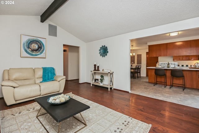 living room featuring a textured ceiling, vaulted ceiling with beams, dark hardwood / wood-style floors, and a notable chandelier