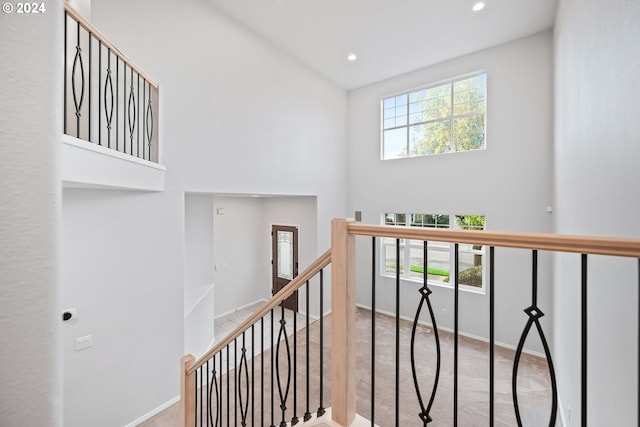 staircase with a healthy amount of sunlight and carpet flooring