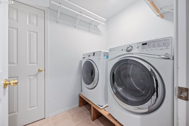 washroom featuring light tile patterned flooring and washing machine and dryer