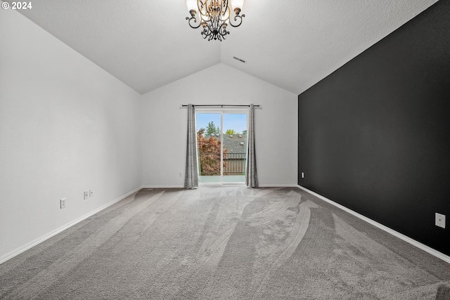 spare room with carpet, vaulted ceiling, and a chandelier