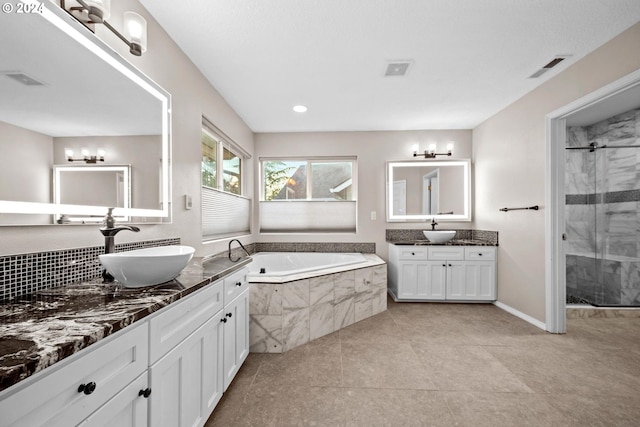 bathroom featuring independent shower and bath, vanity, and tile patterned flooring