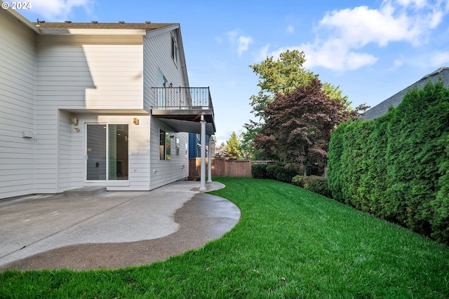 view of yard with a balcony and a patio