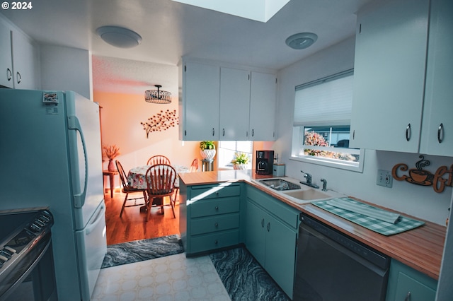 kitchen with light hardwood / wood-style floors, sink, wood counters, and black appliances