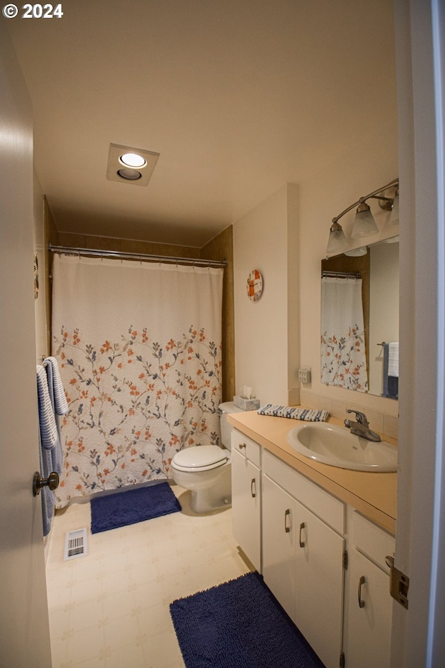 bathroom featuring walk in shower, vanity, and toilet