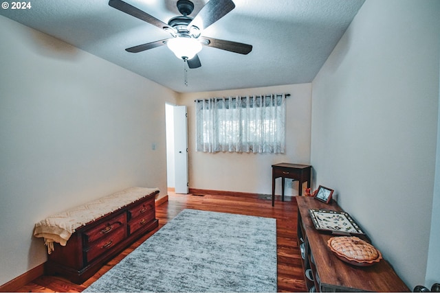 sitting room with ceiling fan, a textured ceiling, and wood-type flooring