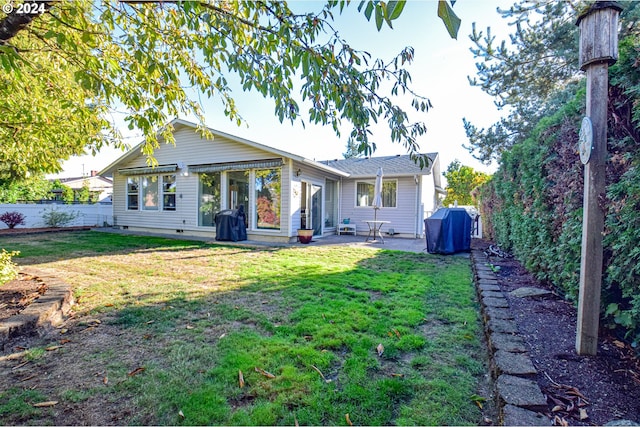 rear view of house featuring a yard and a patio area