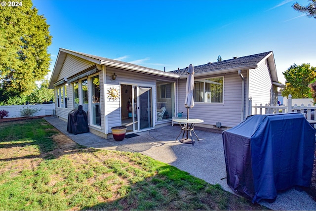 back of house featuring a patio and a lawn