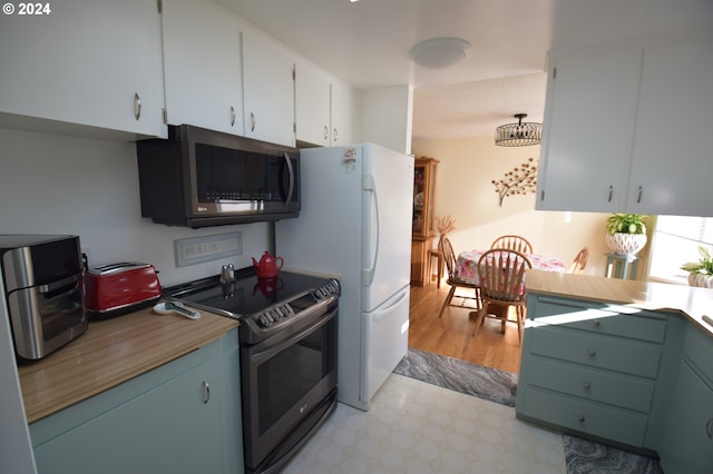 kitchen with light hardwood / wood-style flooring, white cabinetry, and appliances with stainless steel finishes