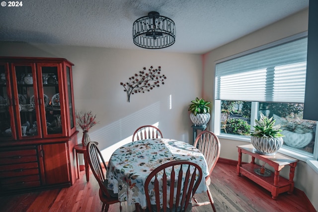 dining room featuring an inviting chandelier, a textured ceiling, and hardwood / wood-style floors