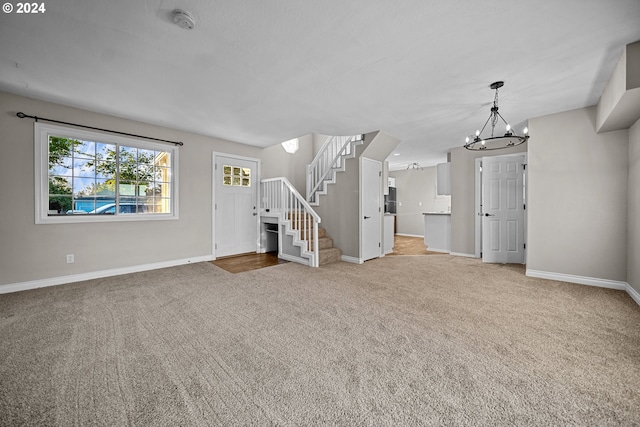 unfurnished living room featuring carpet and a chandelier