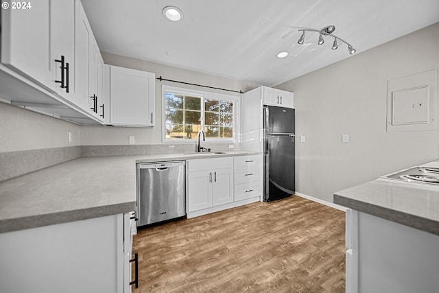 kitchen featuring dishwasher, black refrigerator, white cabinetry, and sink