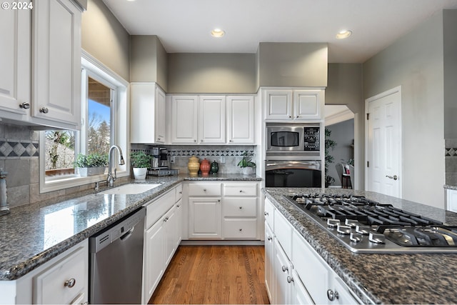 kitchen featuring appliances with stainless steel finishes, tasteful backsplash, white cabinetry, and sink