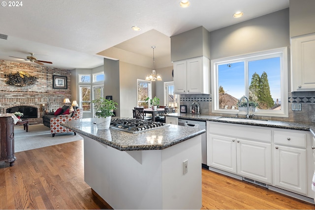 kitchen with white cabinetry, a wealth of natural light, and sink