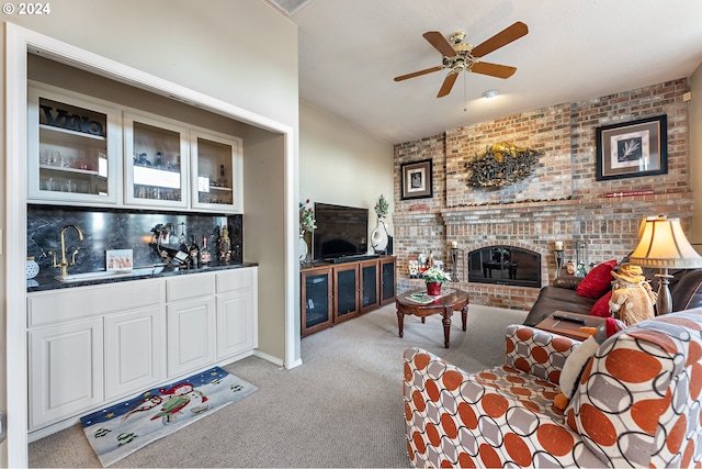 living room featuring light carpet, a fireplace, ceiling fan, and wet bar