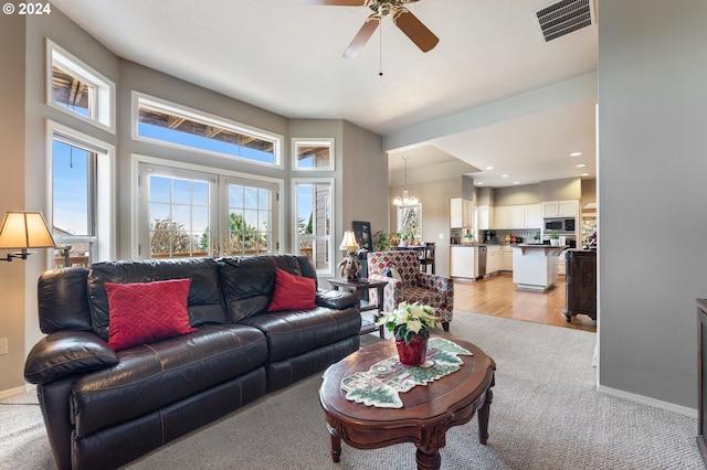 living room featuring light hardwood / wood-style floors and ceiling fan with notable chandelier