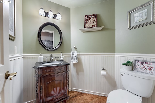 bathroom with toilet, vanity, and hardwood / wood-style flooring