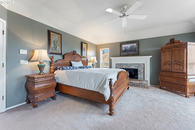 bedroom with light carpet, vaulted ceiling, a brick fireplace, and ceiling fan