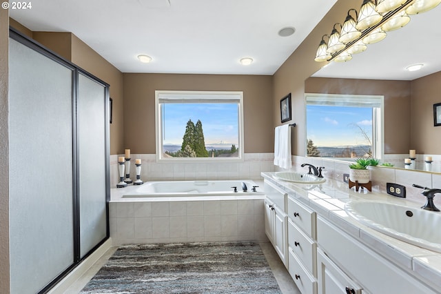 bathroom featuring vanity and a relaxing tiled tub