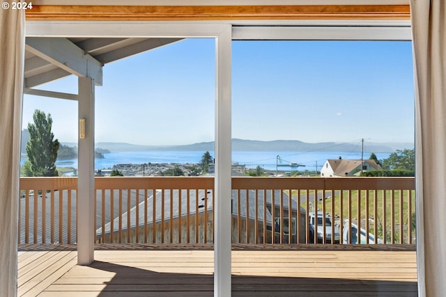 wooden terrace featuring a water and mountain view