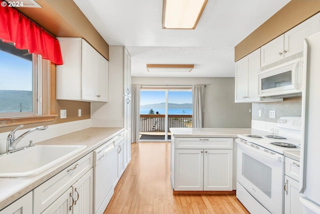 kitchen featuring sink, white appliances, light hardwood / wood-style floors, and white cabinets