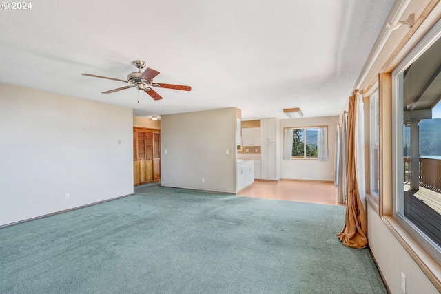 unfurnished living room with light carpet and ceiling fan