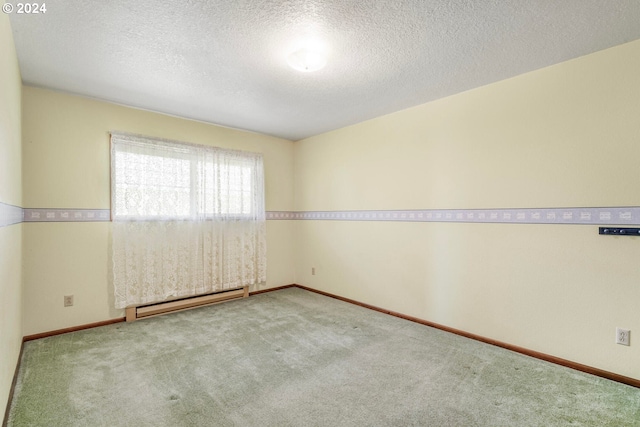 carpeted spare room with a textured ceiling and a baseboard heating unit