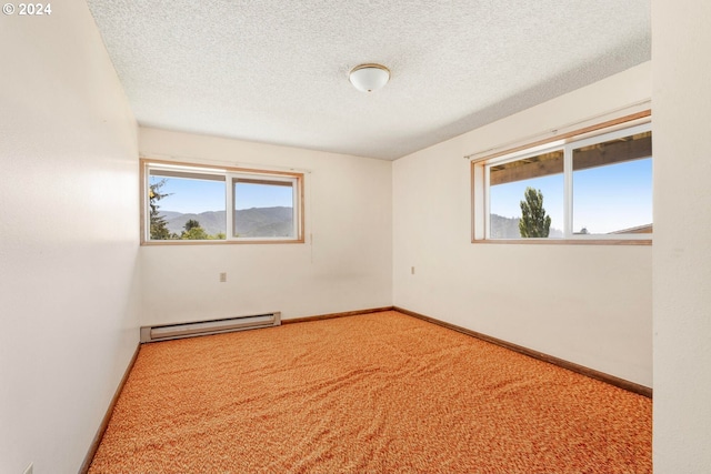 carpeted spare room with a baseboard heating unit and a textured ceiling