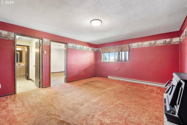 carpeted empty room featuring a baseboard heating unit and a textured ceiling