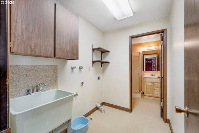 washroom featuring cabinets, sink, and hookup for an electric dryer