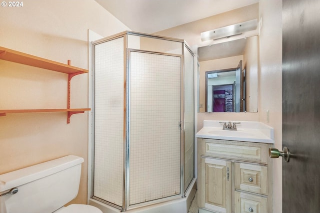 bathroom featuring vanity, a shower with shower door, and toilet