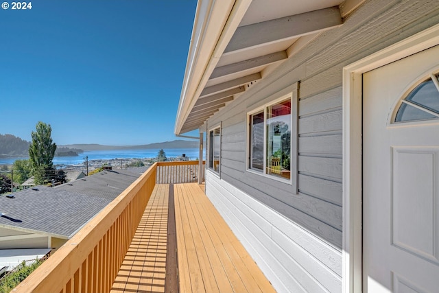 wooden deck featuring a water and mountain view