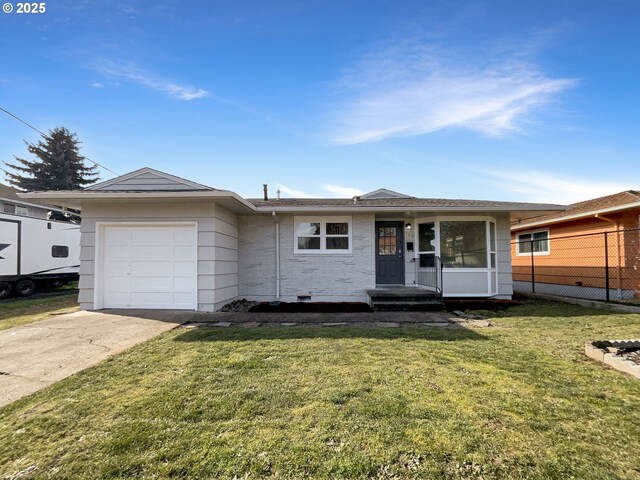 ranch-style home featuring an attached garage, concrete driveway, a front yard, and fence